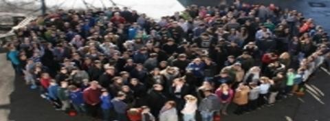 Menschen stehen zusammen in Form eines Herzens