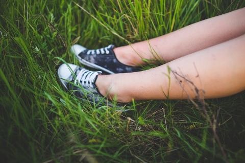 Mensch sitzt in Wiese